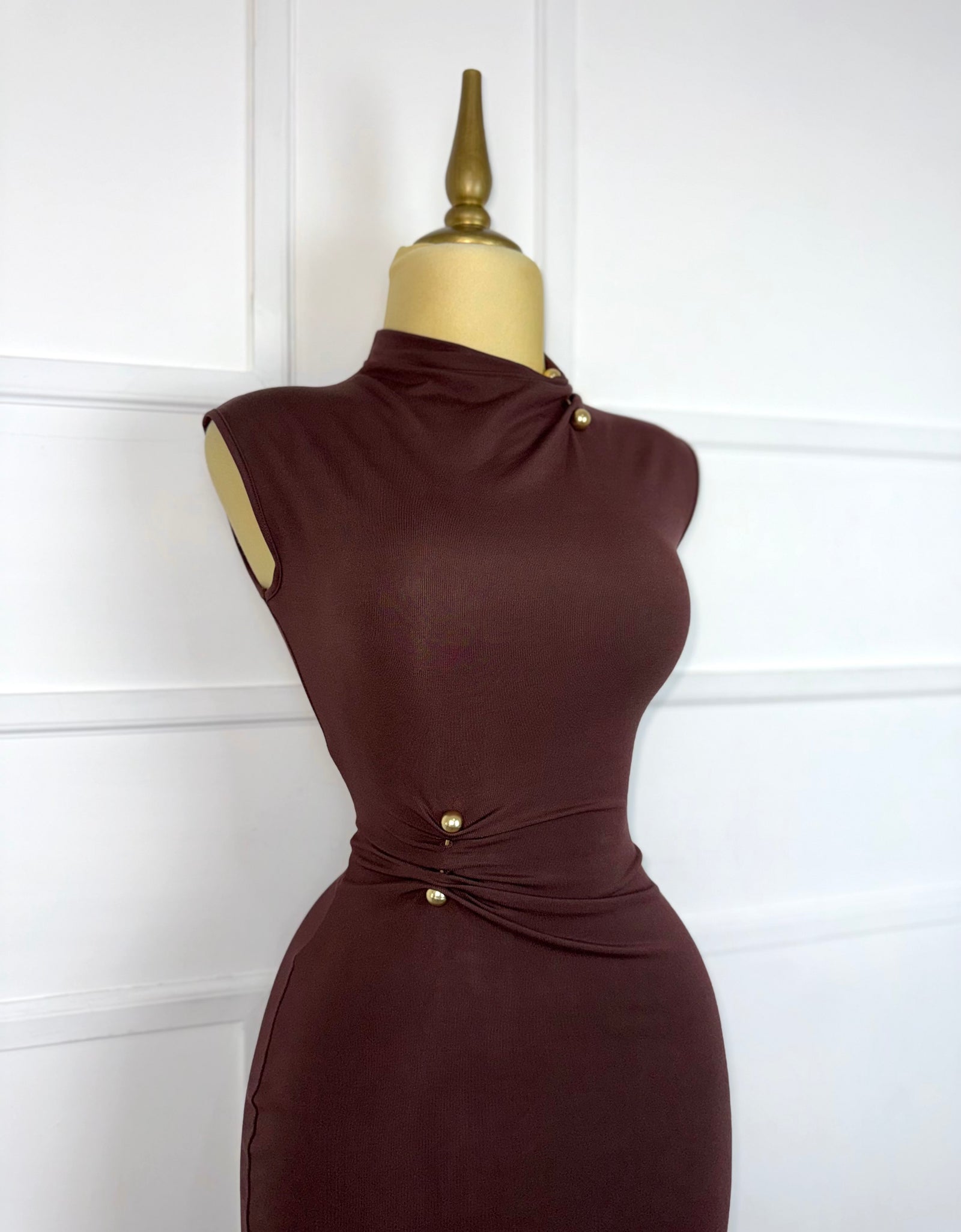 Vestido café con broches dorados