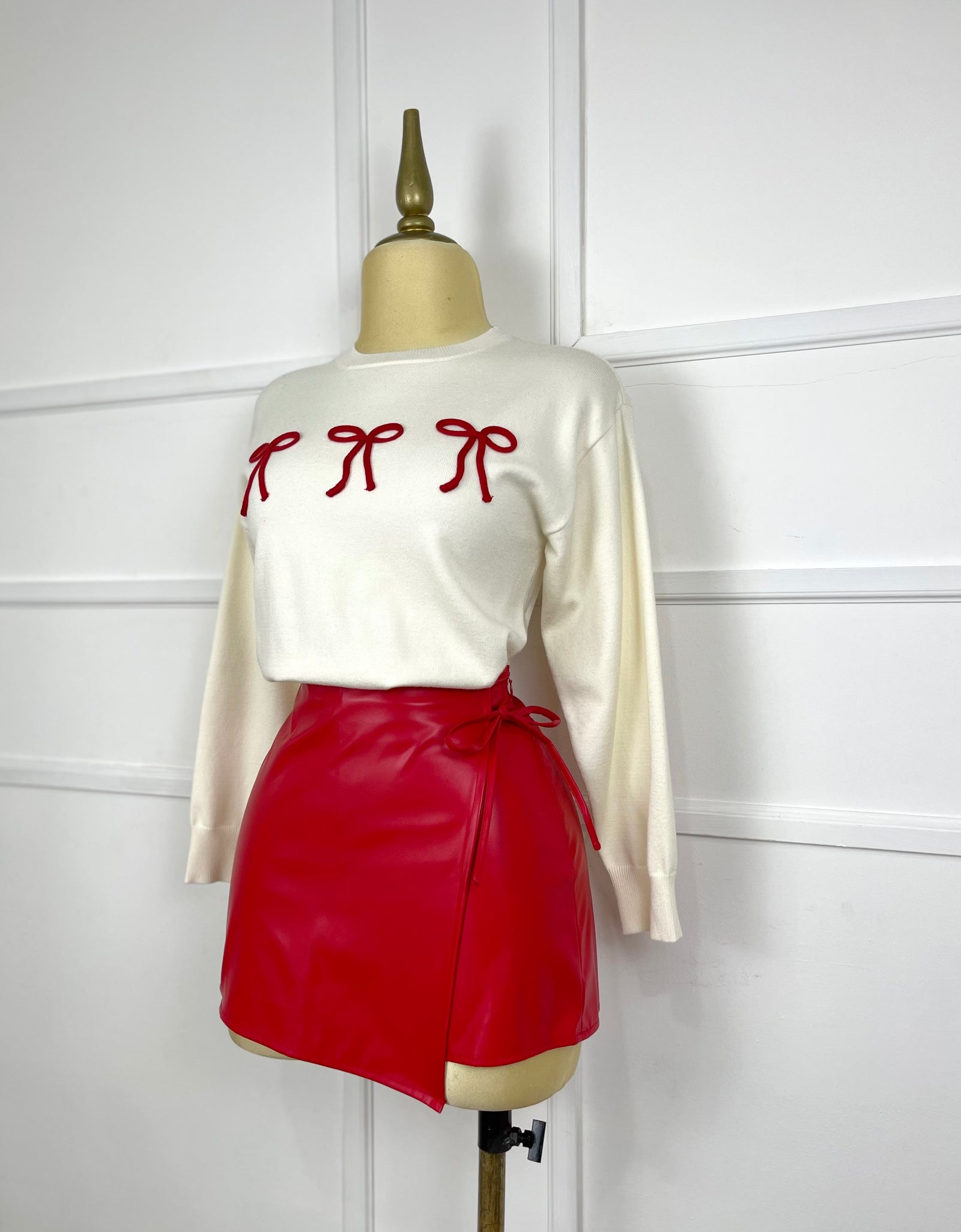 Suéter beige con moños rojos