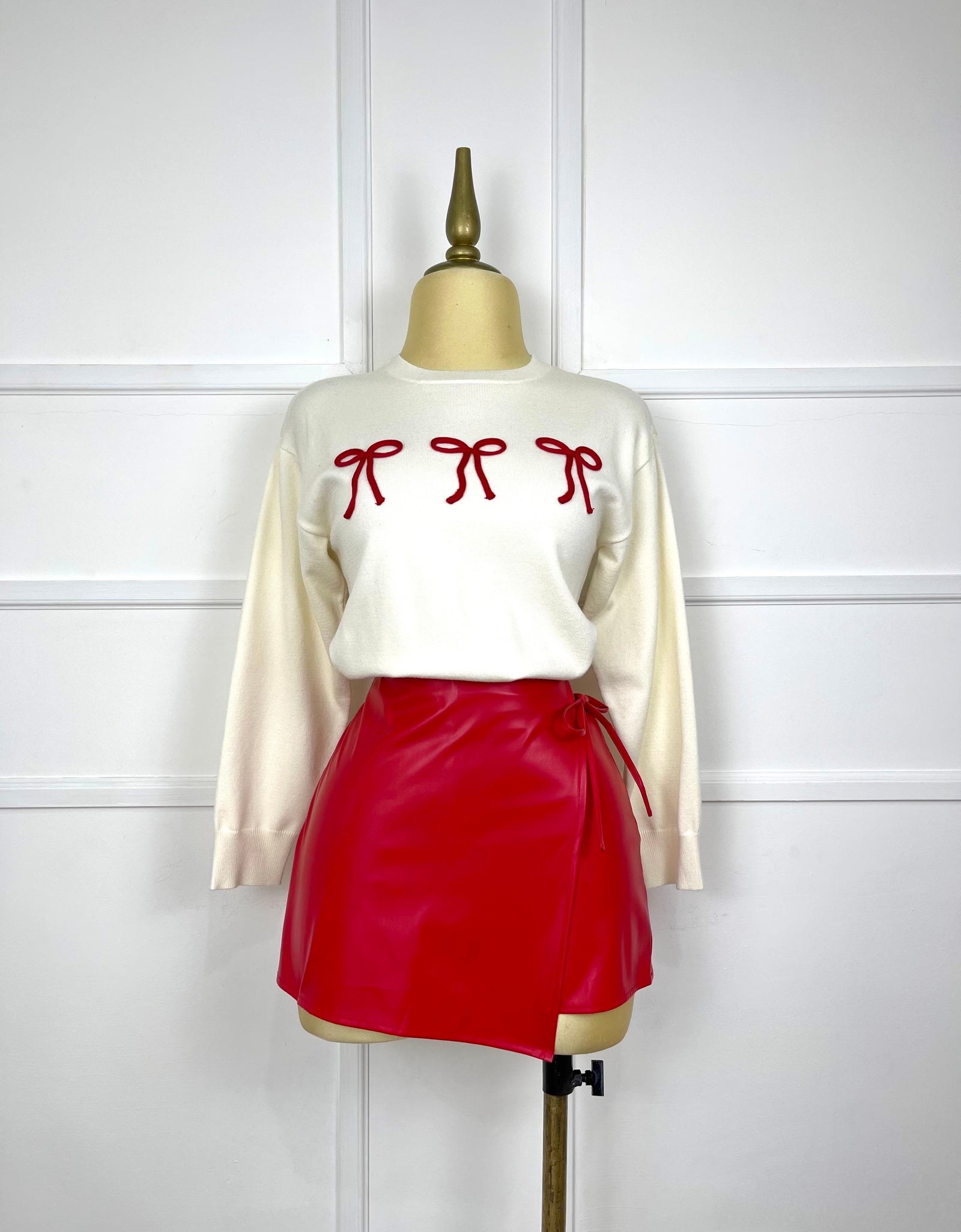 Suéter beige con moños rojos