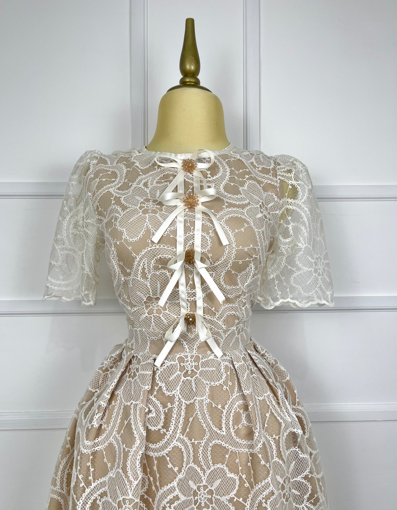 Vestido beige con encaje y moños