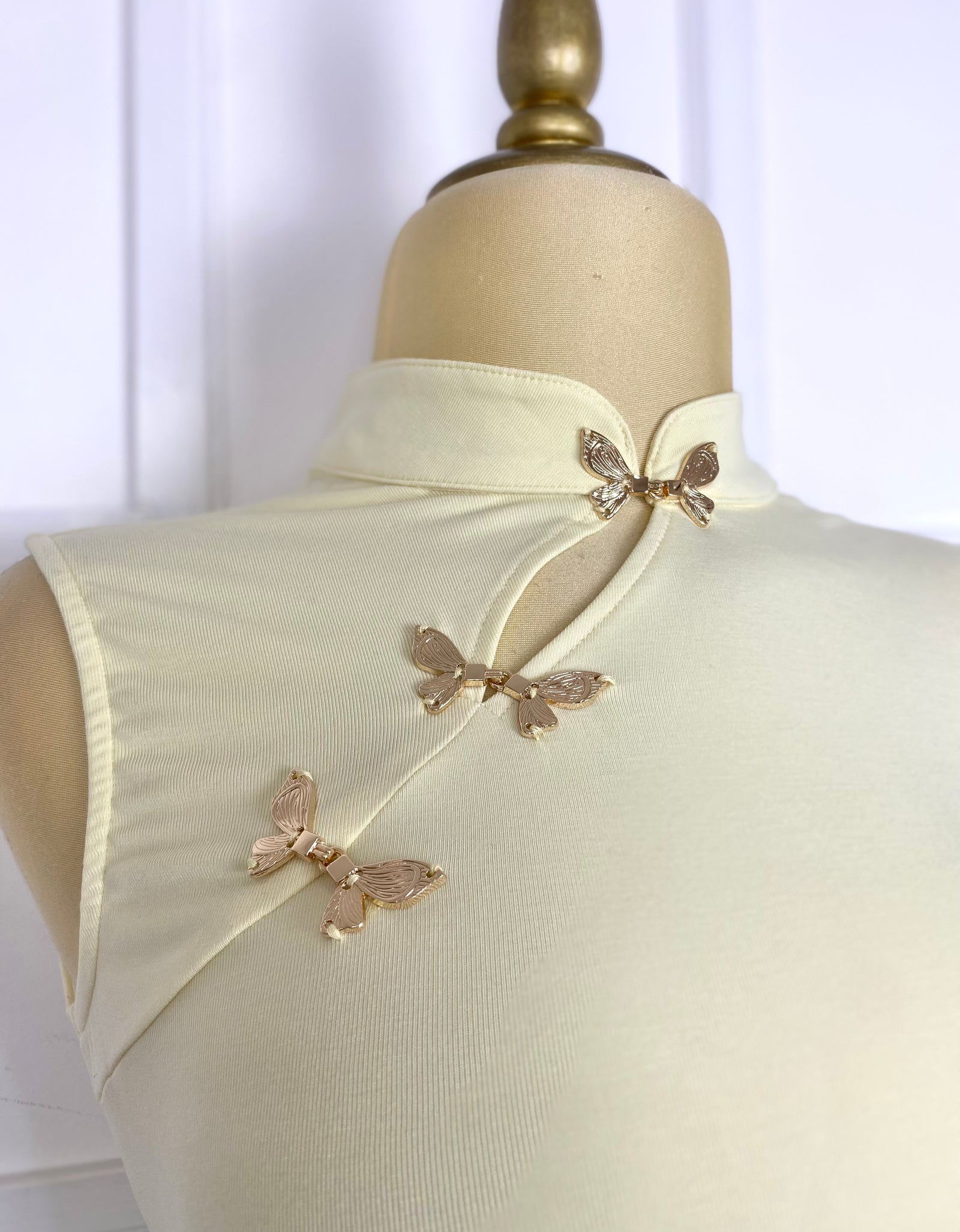 Blusa amarilla con broches mariposas