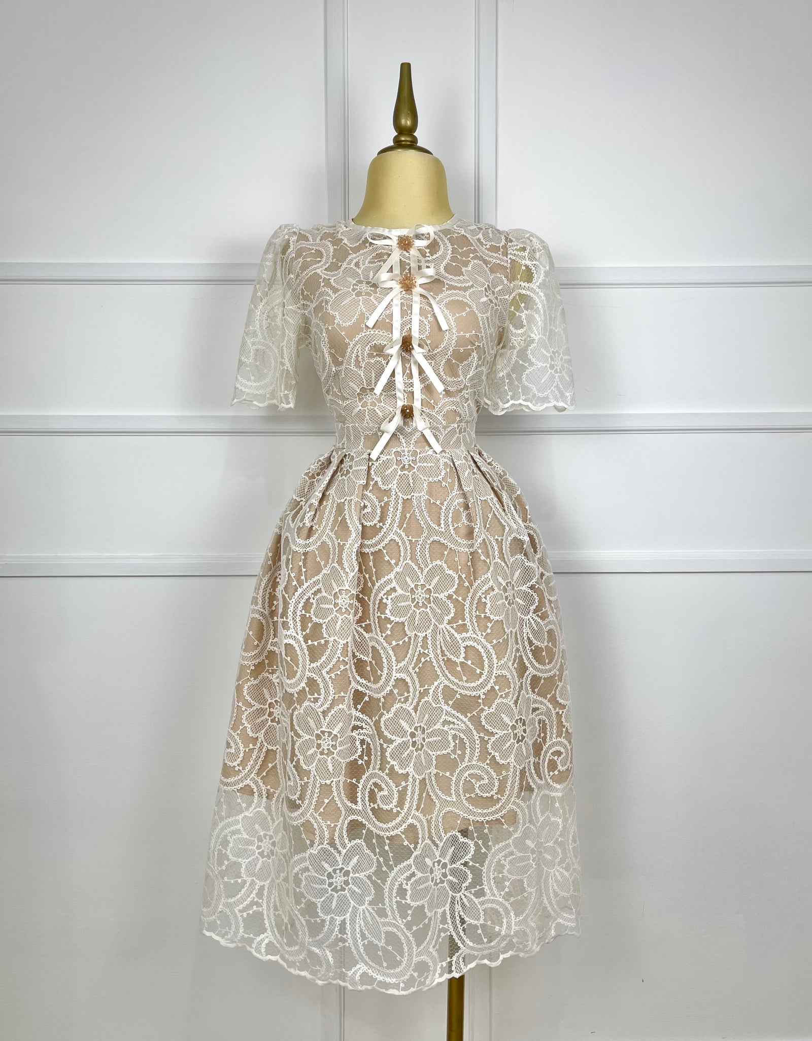 Vestido beige con encaje y moños